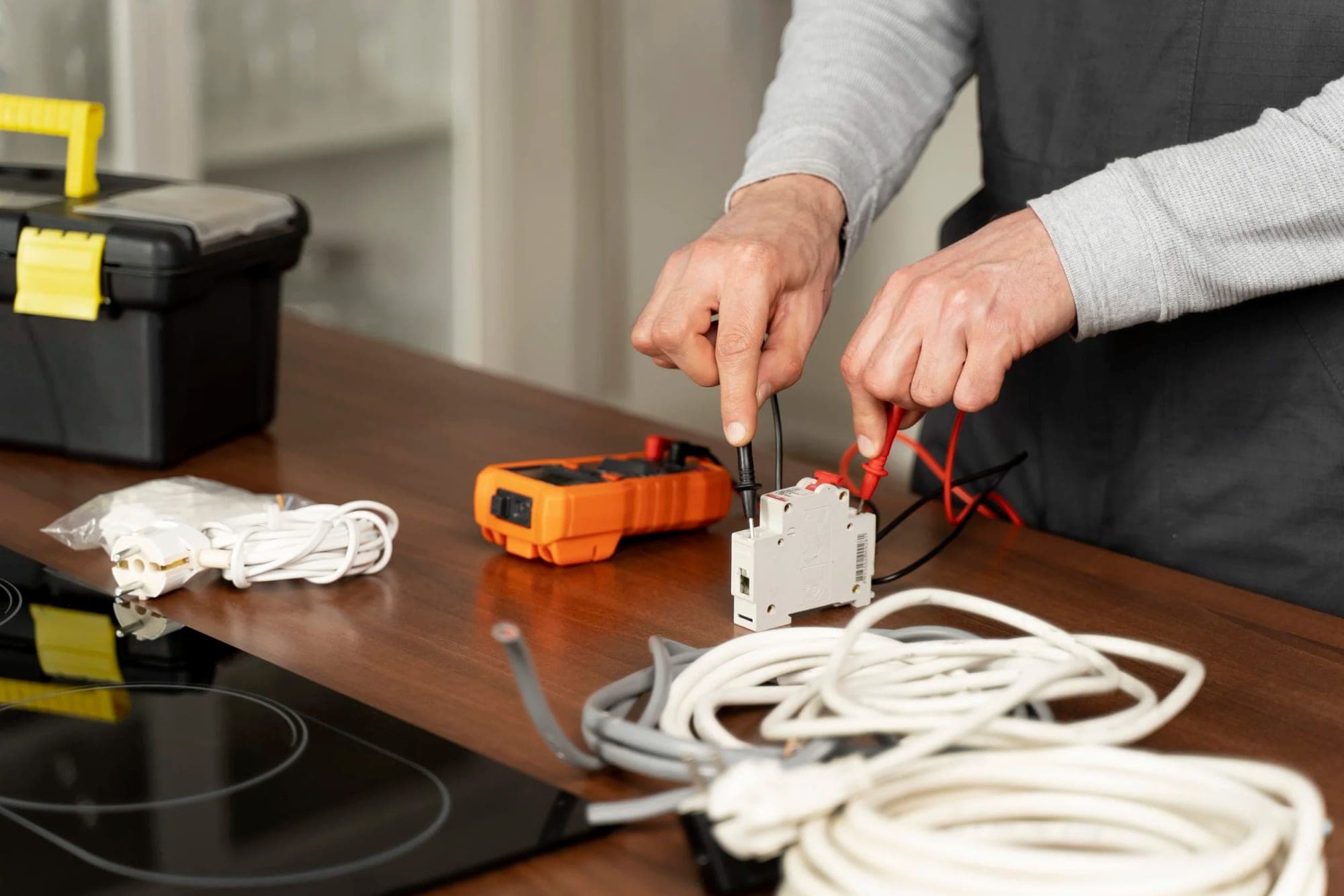 Händer som mäter på en dvärgbrytare med en multimeter